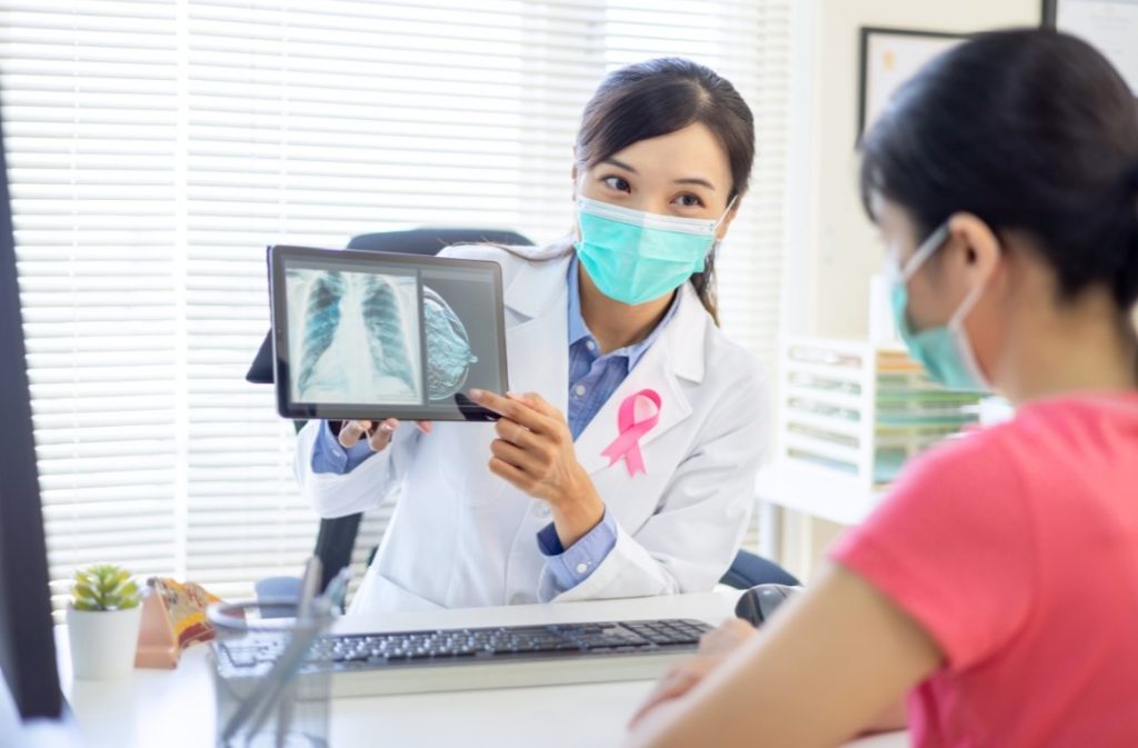 doctor showing patient an image of their breast mammogram